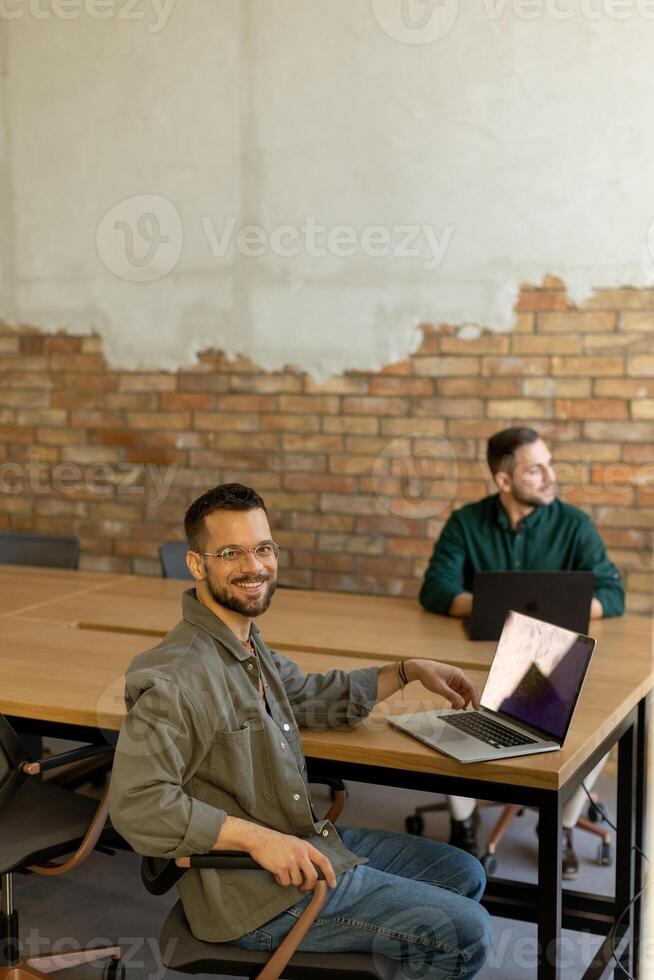 Collaboration in Motion, Professionals Working Together in a Modern Brick-Walled Office photo