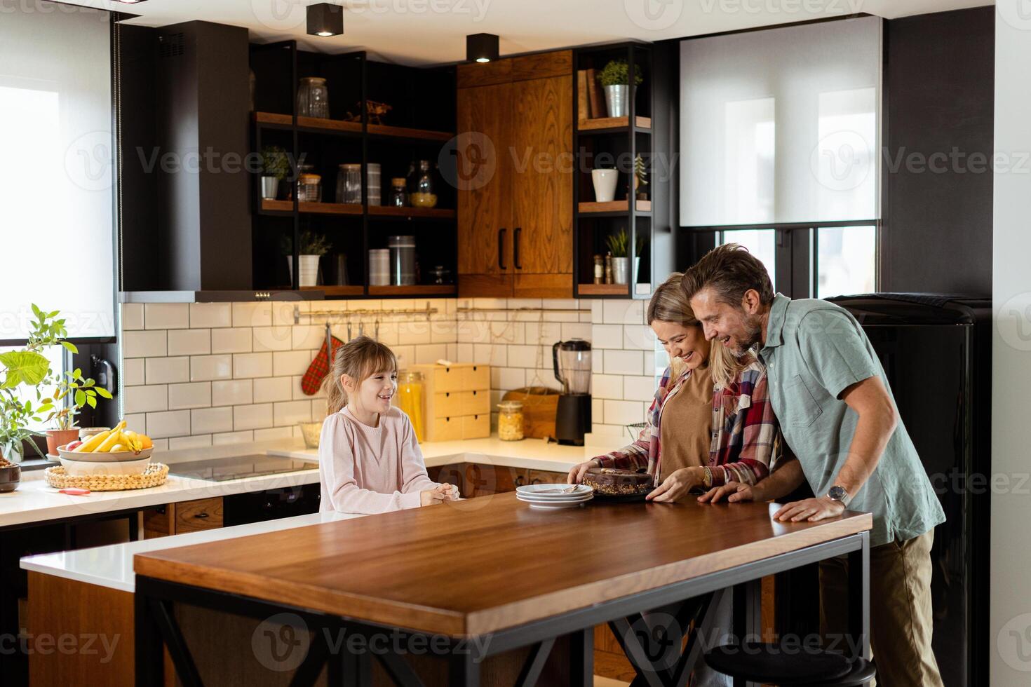 Joyful Family Enjoying Homemade Chocolate Cake in Cozy Kitchen photo
