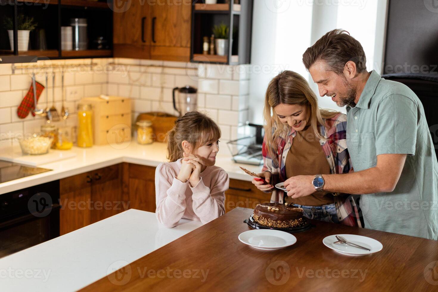 Joyful Family Enjoying Homemade Chocolate Cake in Cozy Kitchen photo
