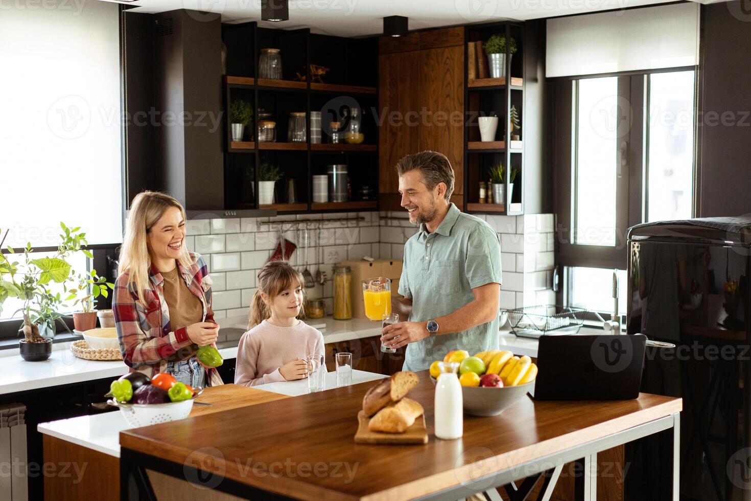 Family chatting and preparing food around a bustling kitchen counter filled with fresh ingredients and cooking utensils photo