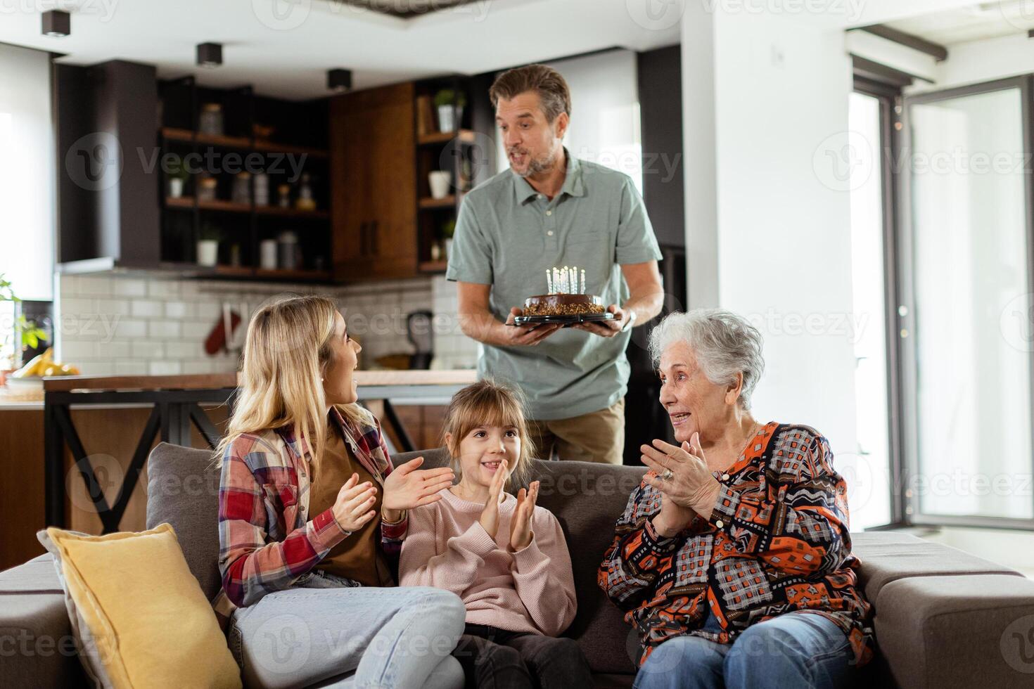 Joyous Family Celebrating Grandmothers Birthday With Cake in a Cozy Living Room photo