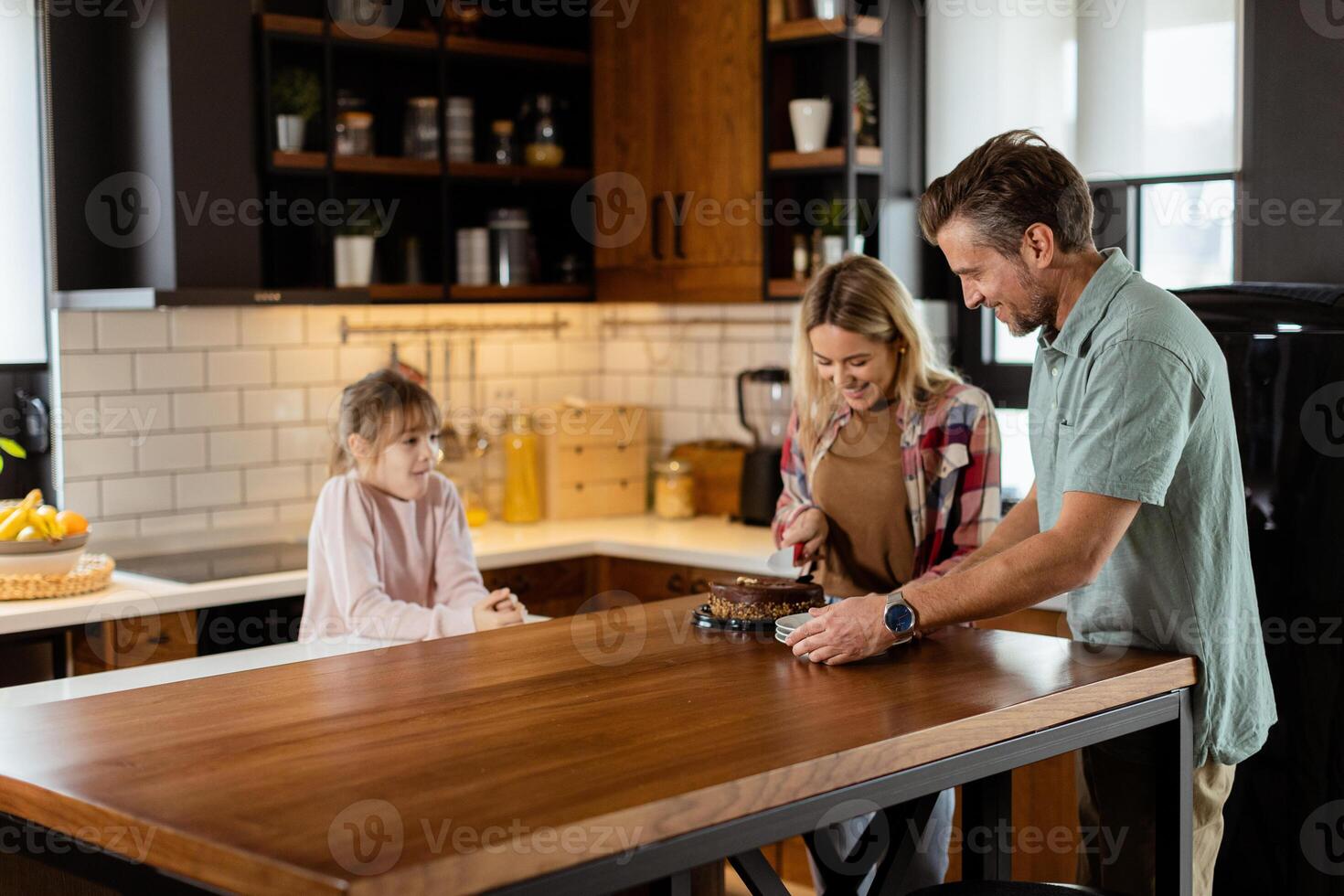 Joyful Family Enjoying Homemade Chocolate Cake in Cozy Kitchen photo
