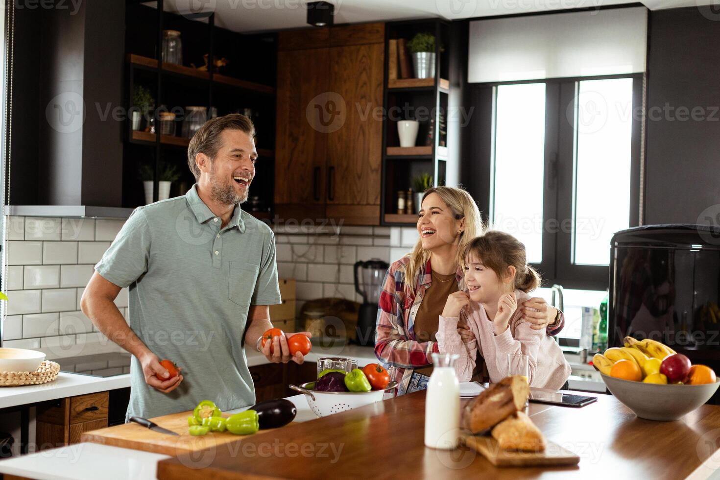 Family chatting and preparing food around a bustling kitchen counter filled with fresh ingredients and cooking utensils photo