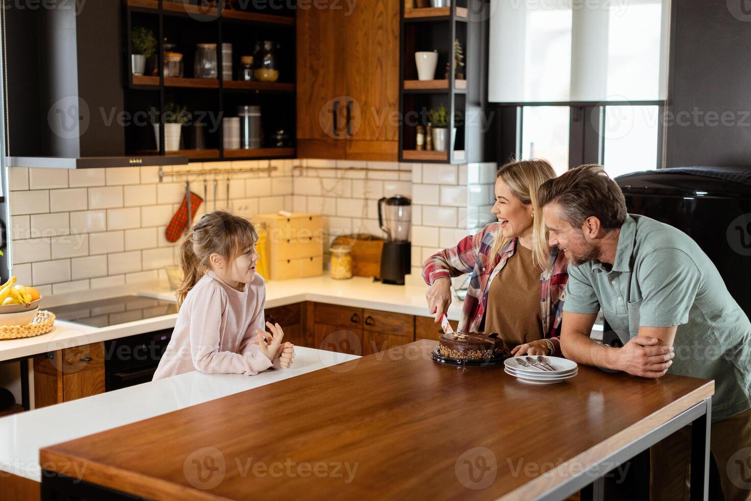 Joyful Family Enjoying Homemade Chocolate Cake in Cozy Kitchen photo