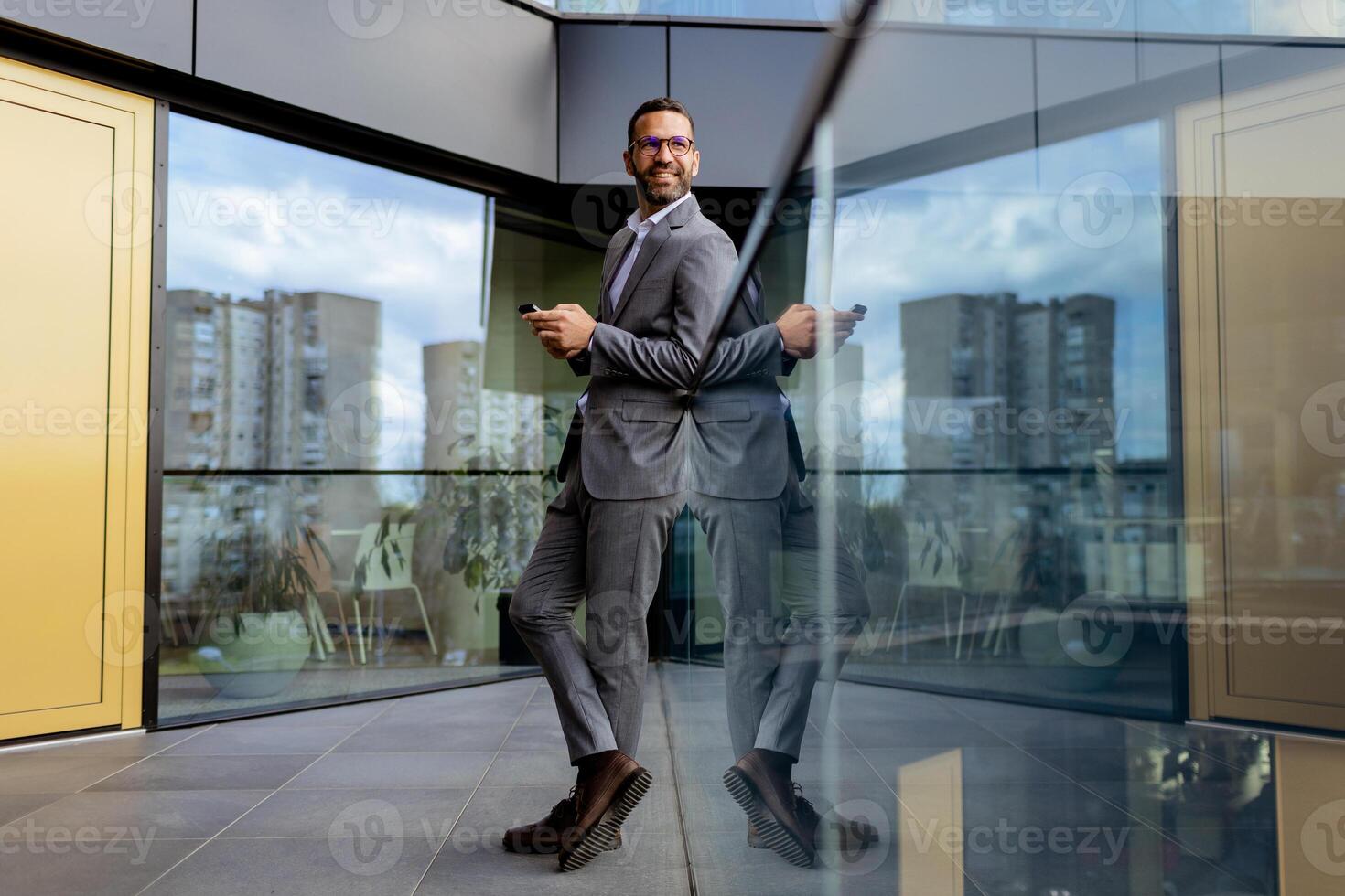 confidente empresario sonriente en agudo traje en contra moderno vaso oficina fachada foto