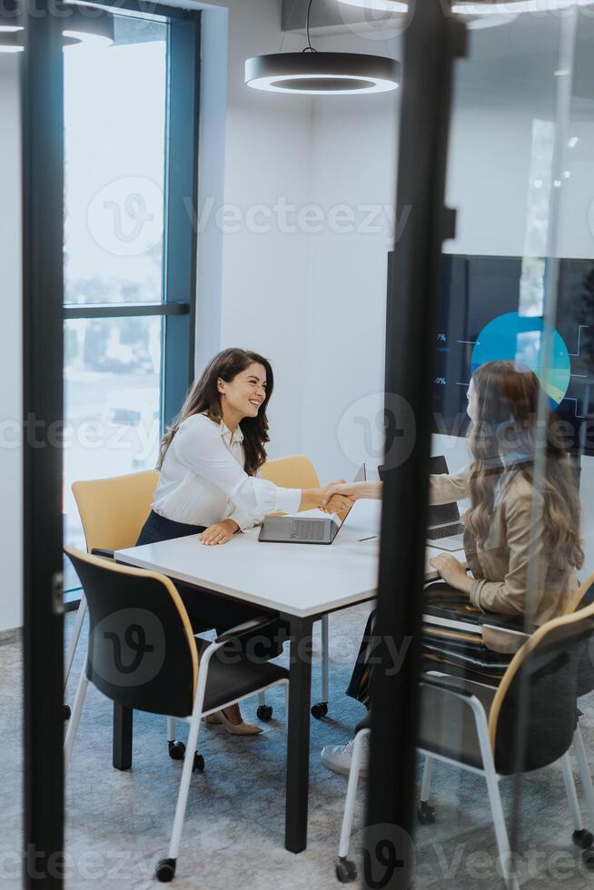 Young business women discussing in cubicle at the office photo