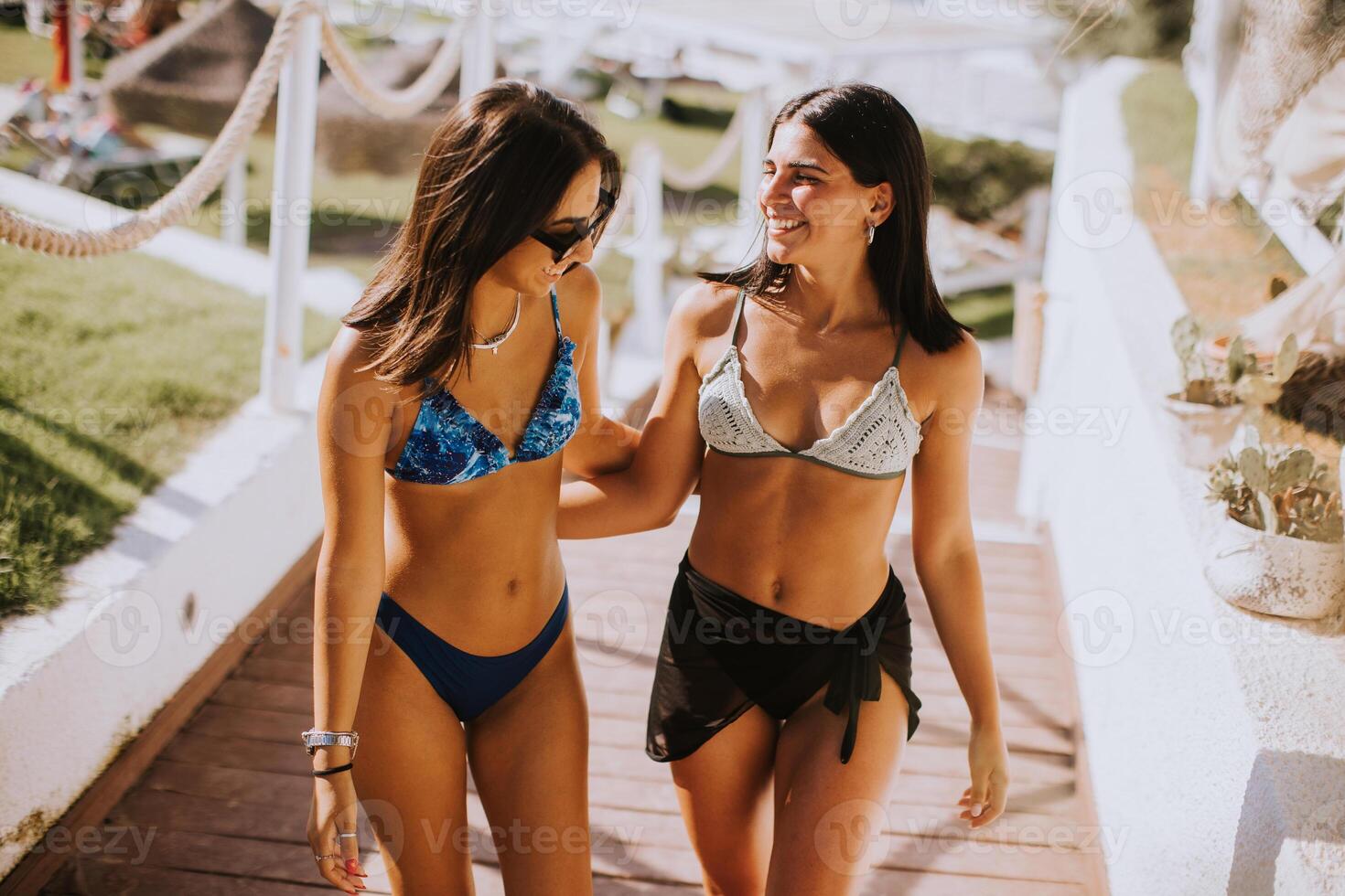 Two pretty young woman having fun on the seaside photo
