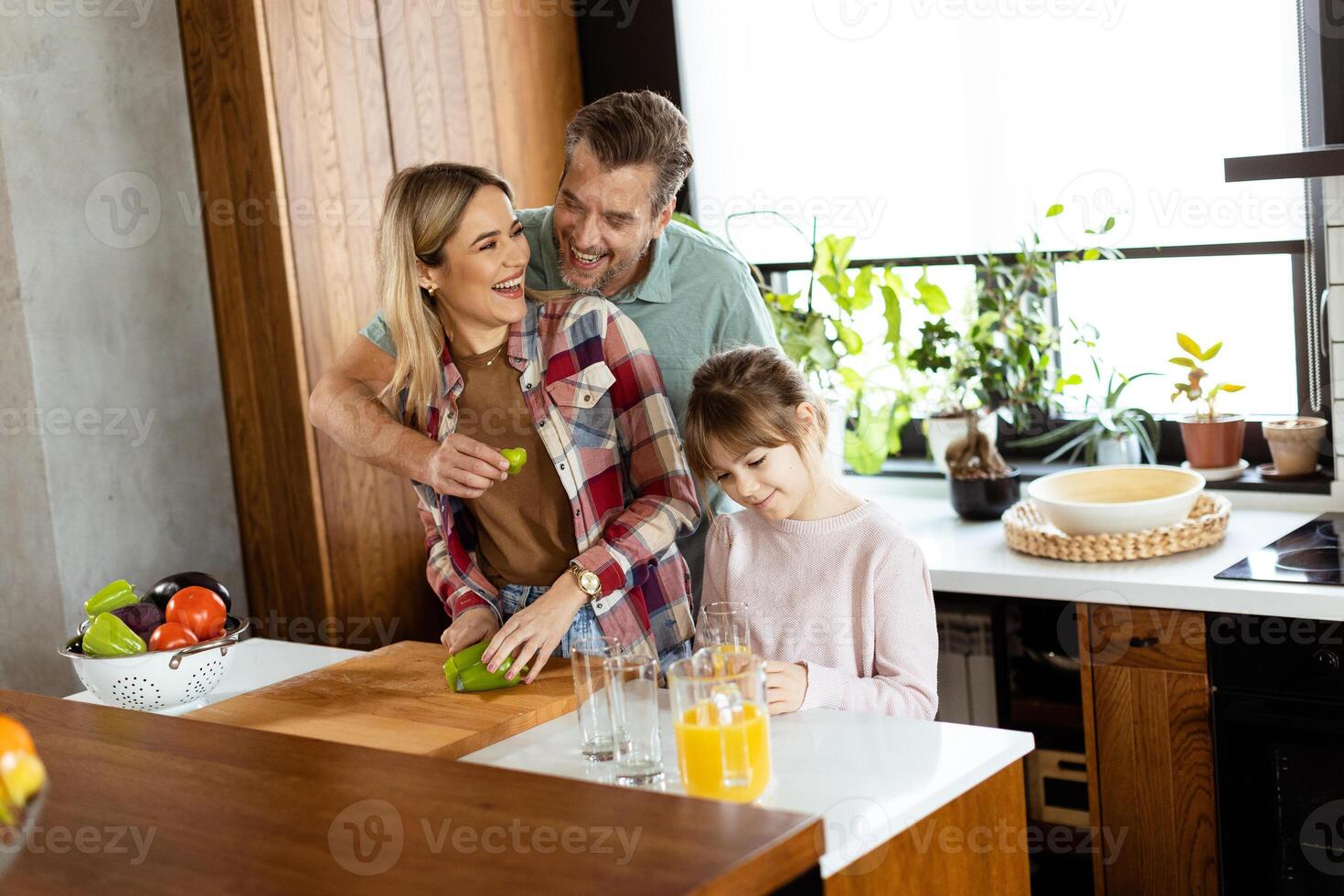 Family chatting and preparing food around a bustling kitchen counter filled with fresh ingredients and cooking utensils photo