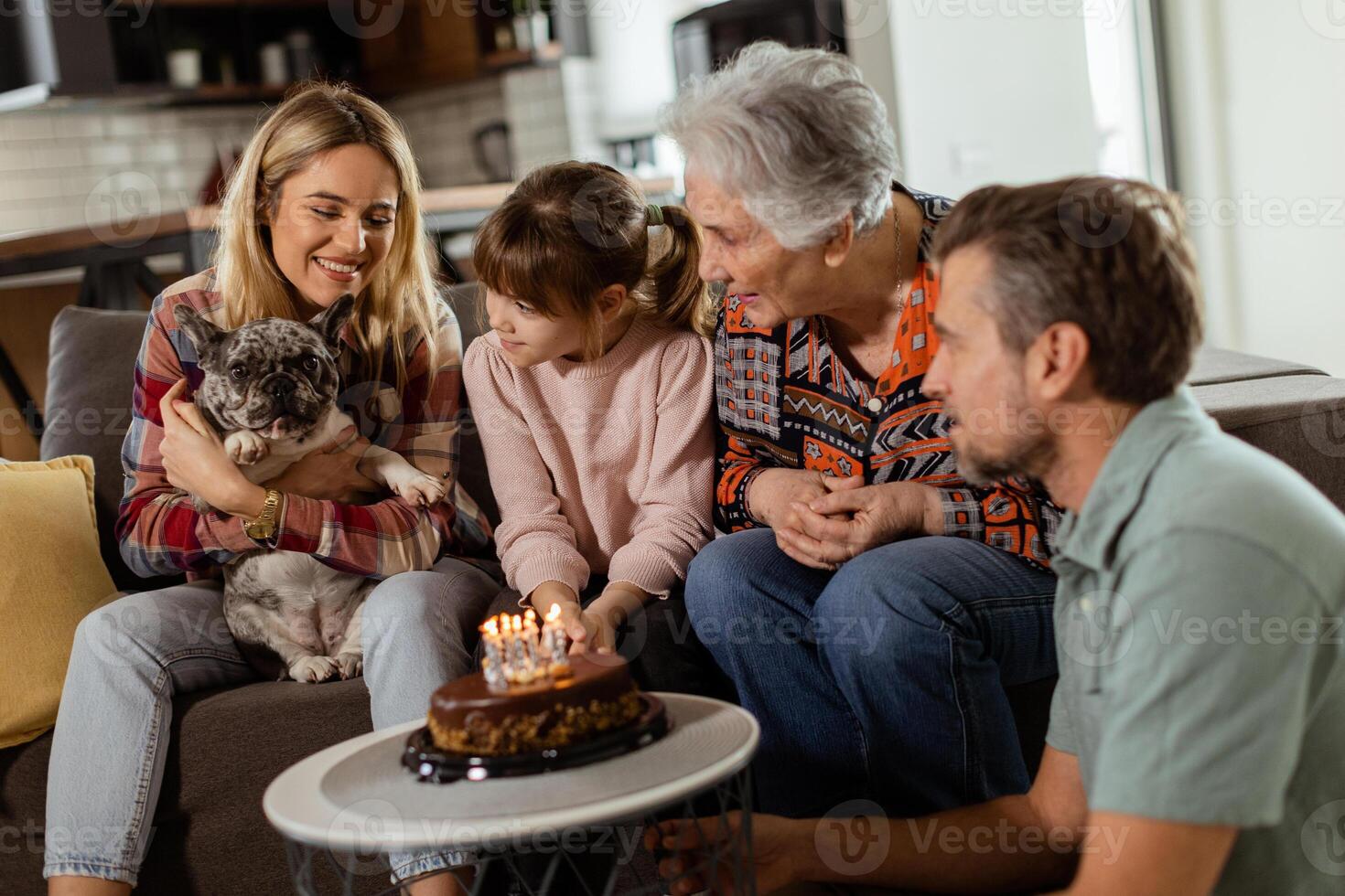 Joyous Family Celebrating Grandmothers Birthday With Cake in a Cozy Living Room photo