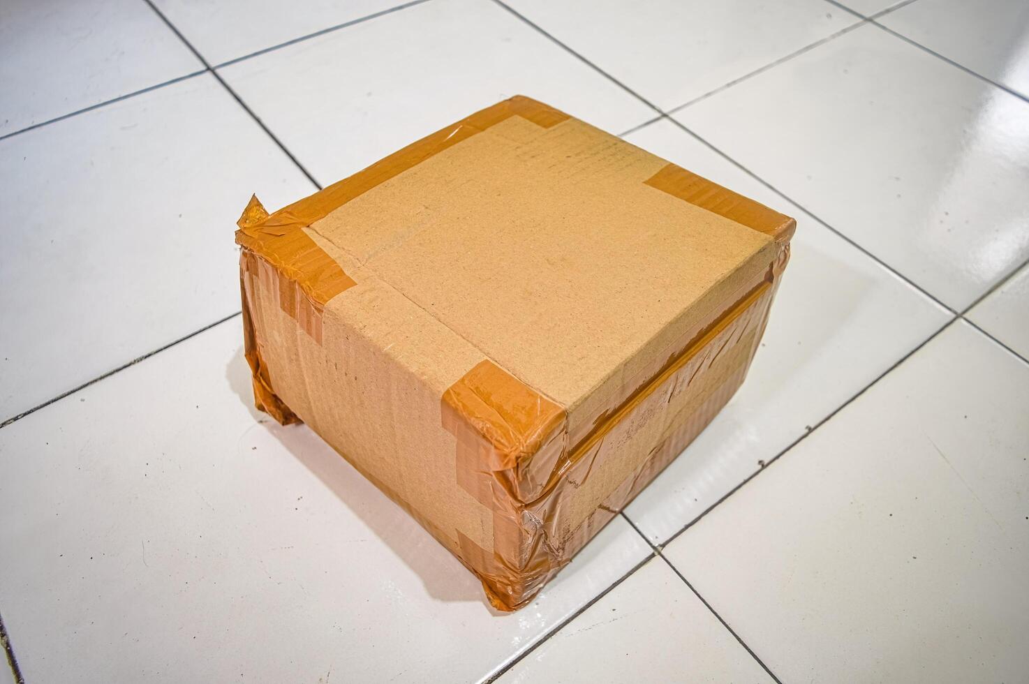 Cardboard boxes insulated with tape for sending packages lay on the floor photo