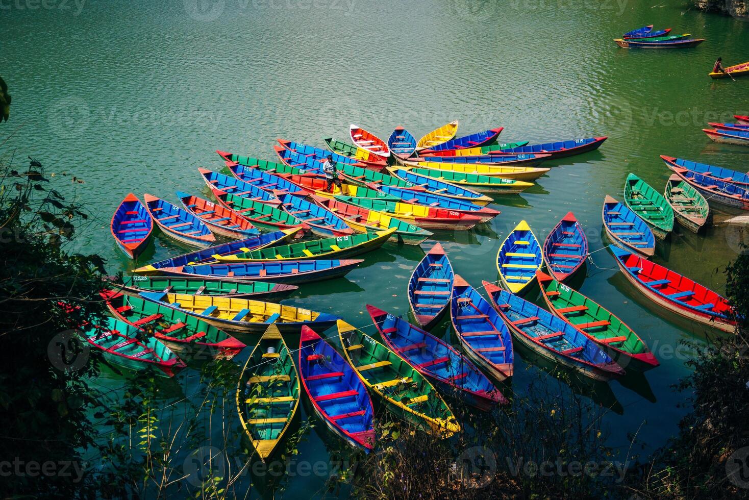Phewa Lake with multicoloured boats in the valley of Pokhara in central Nepal. photo