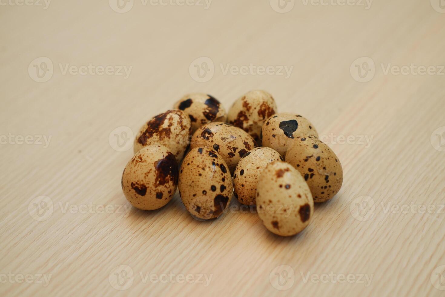 Quail eggs on a wooden background. Close-up, selective focus. photo