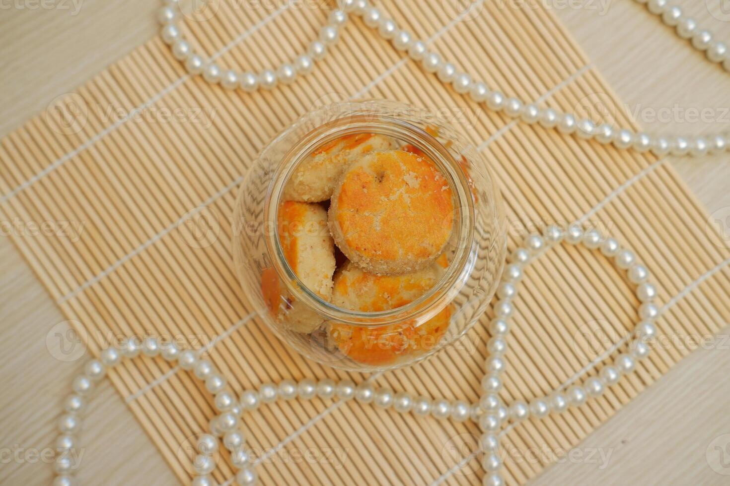 galletas en un vaso tarro en un bambú estera con perlas foto