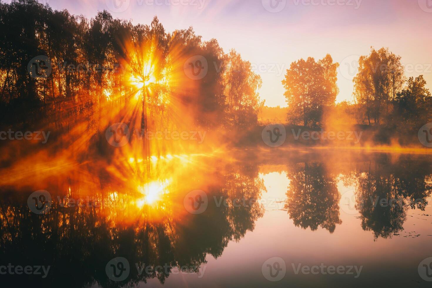 amanecer en un lago o río con un cielo reflejado en el agua, abedul arboles en el apuntalar y el rayos de sol rotura mediante ellos y niebla en otoño. estética de Clásico película. foto