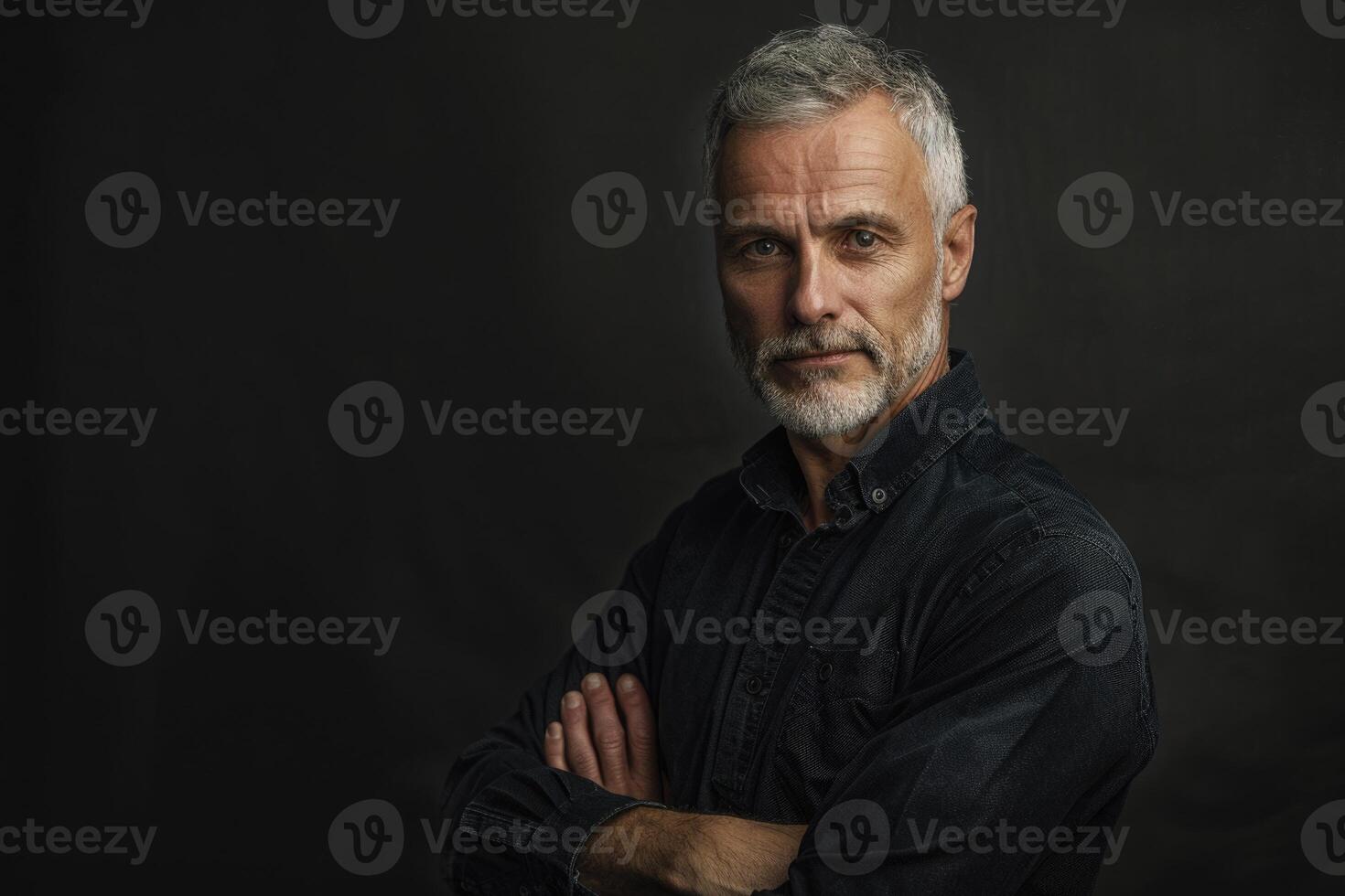 Middle aged man posing against black background with copy space. photo