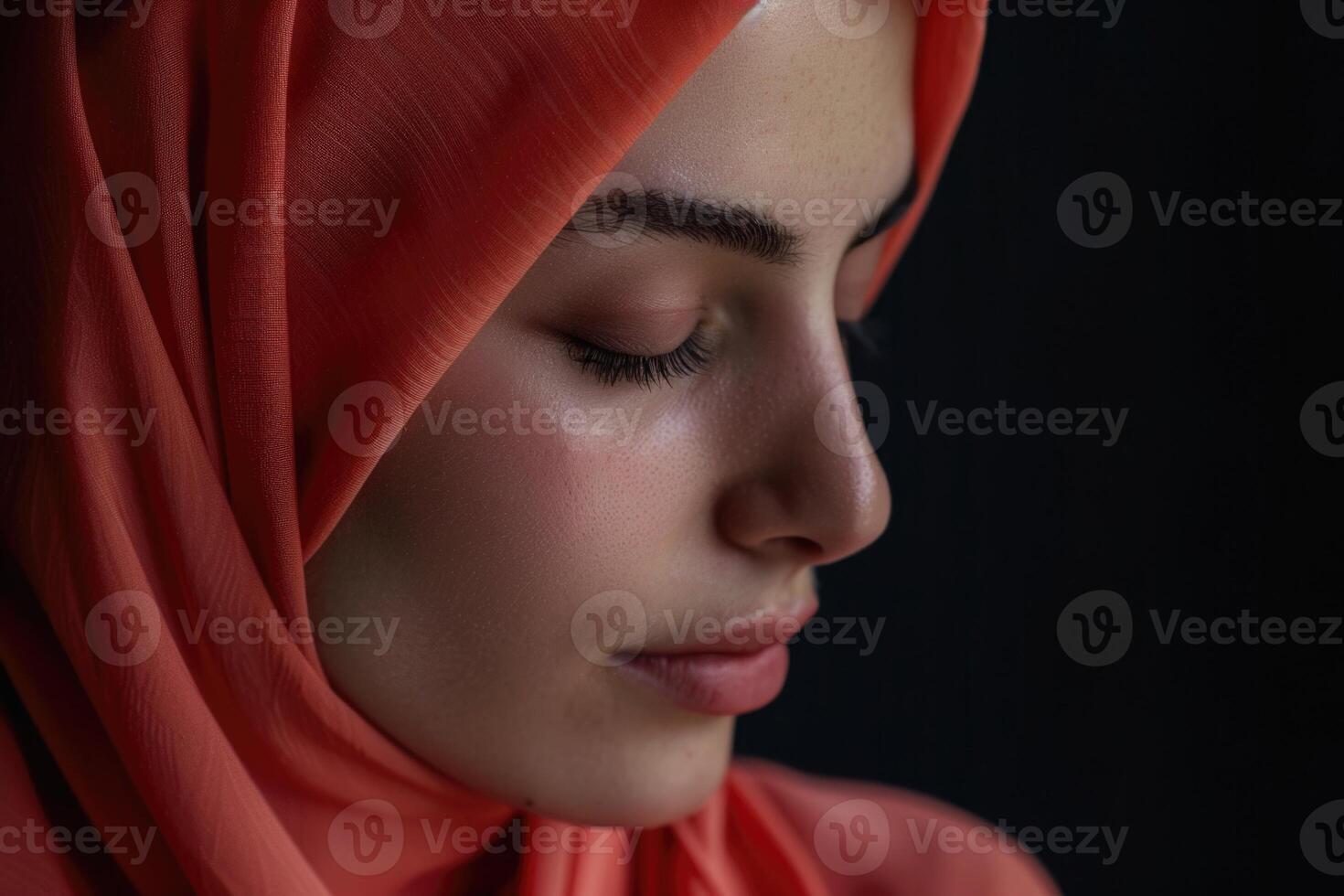 A Muslim woman with closed eyes on a black background. Arab girl in hijab in profile. photo