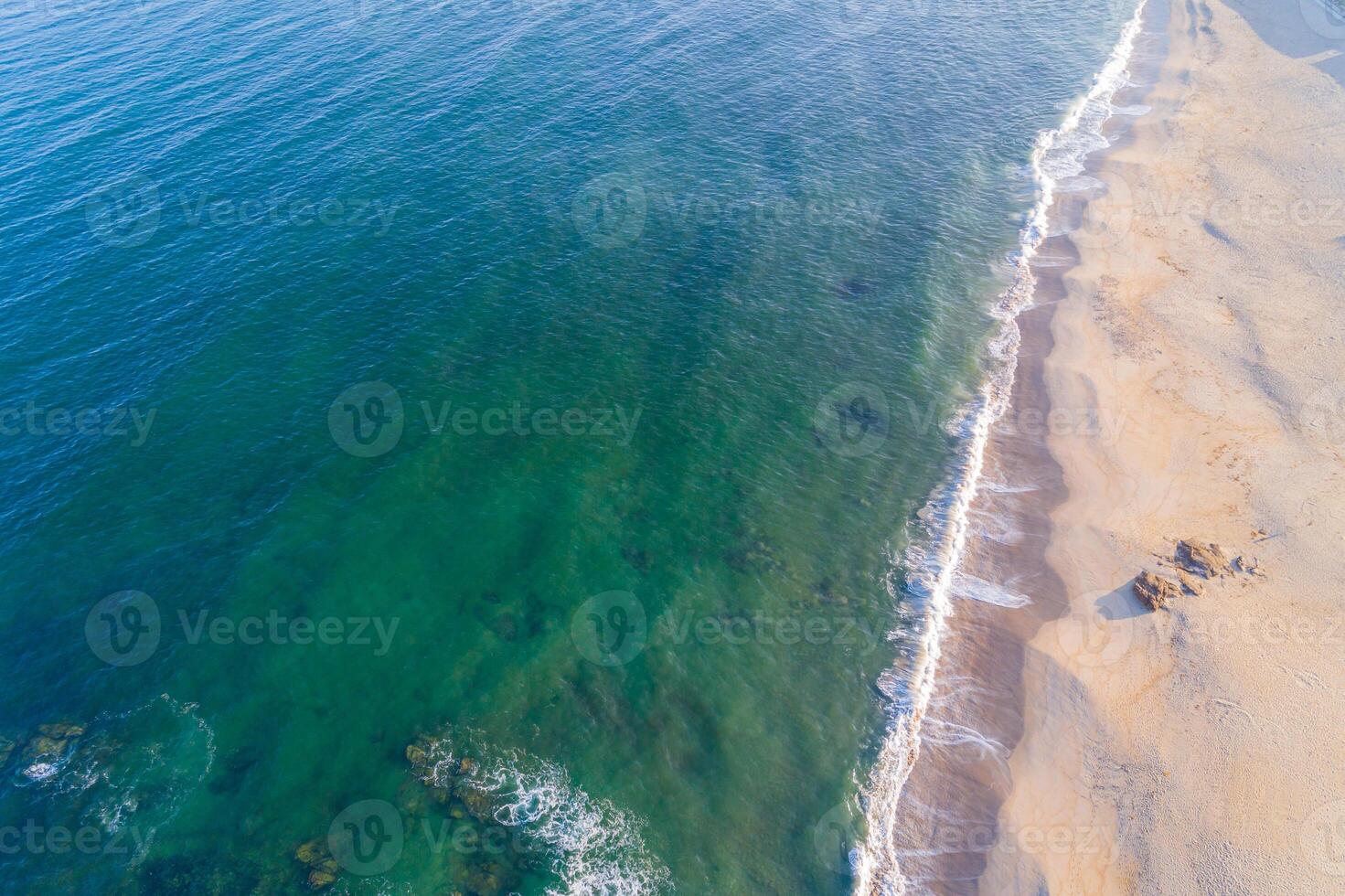 parte superior aéreo ver de el apuntalar de un vacío playa en verano a amanecer, zumbido Disparo foto