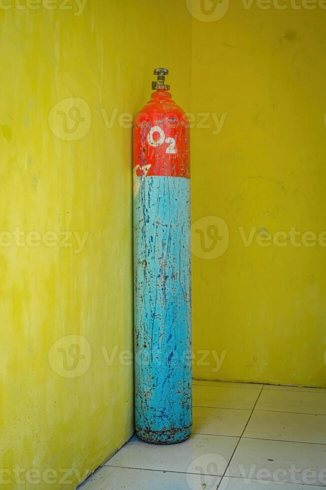 an oxygen cylinder isolated on yellow wall. Perfect for medical content. photo