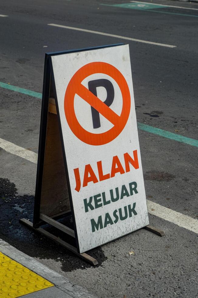 a board containing a sign that no parking is permitted on the side of the road. Translation on board Entrance and Exit. photo