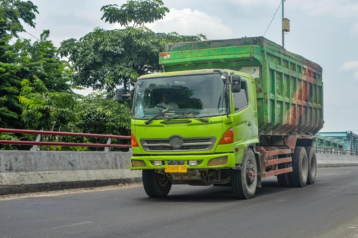 un hino tugurio camión pasa terminado un hormigón autopista puente, Indonesia, dieciséis enero 2024. foto