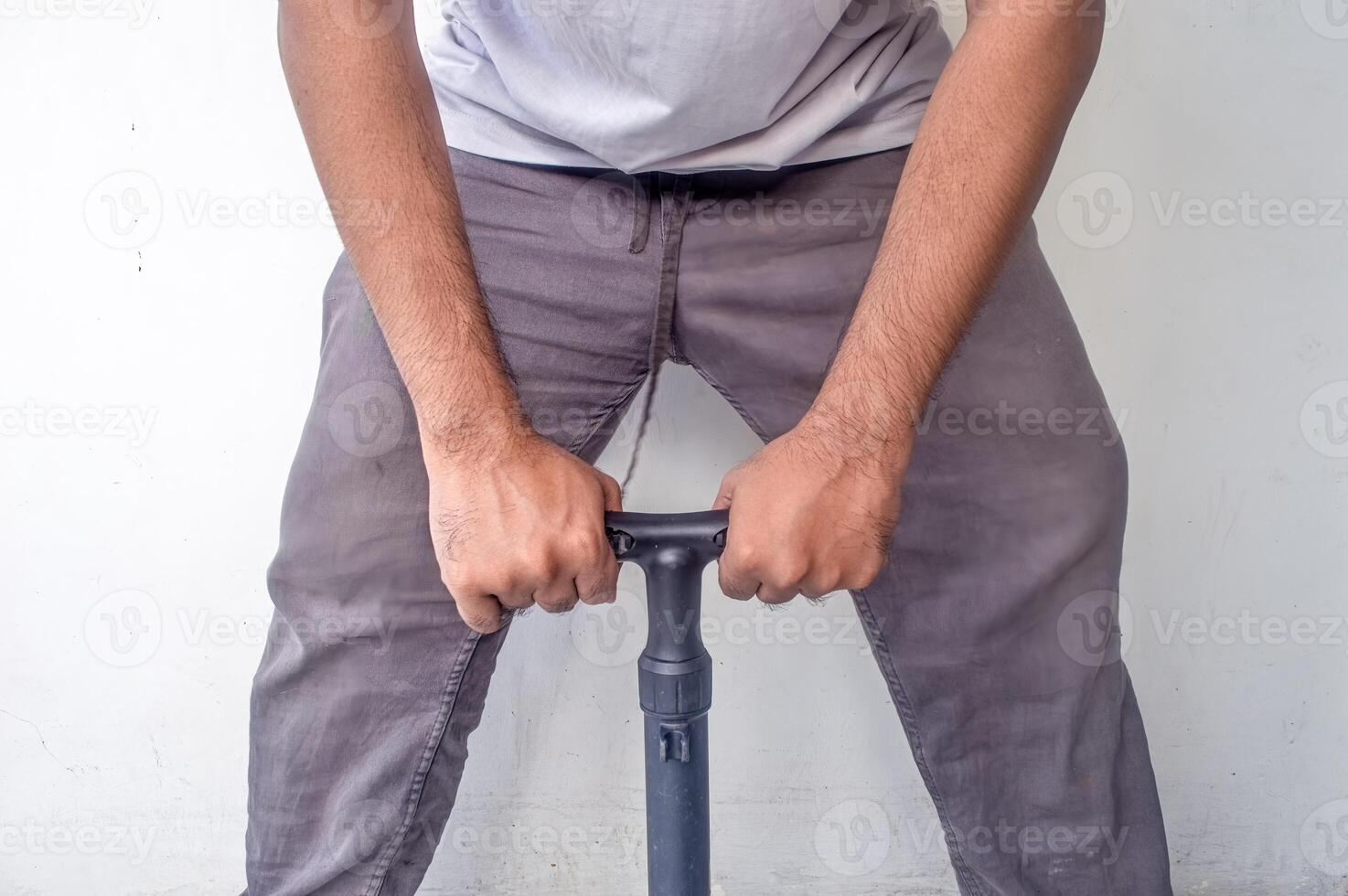 an adult man who is pumping a bicycle as hard as he can using a manual pump photo