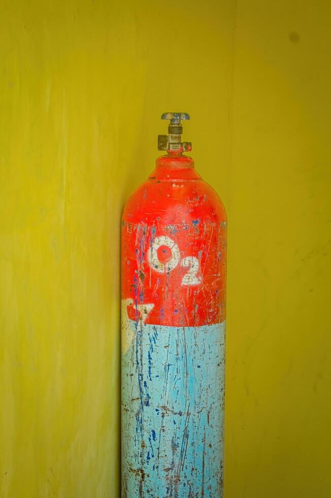 an oxygen cylinder isolated on yellow wall. Perfect for medical content. photo