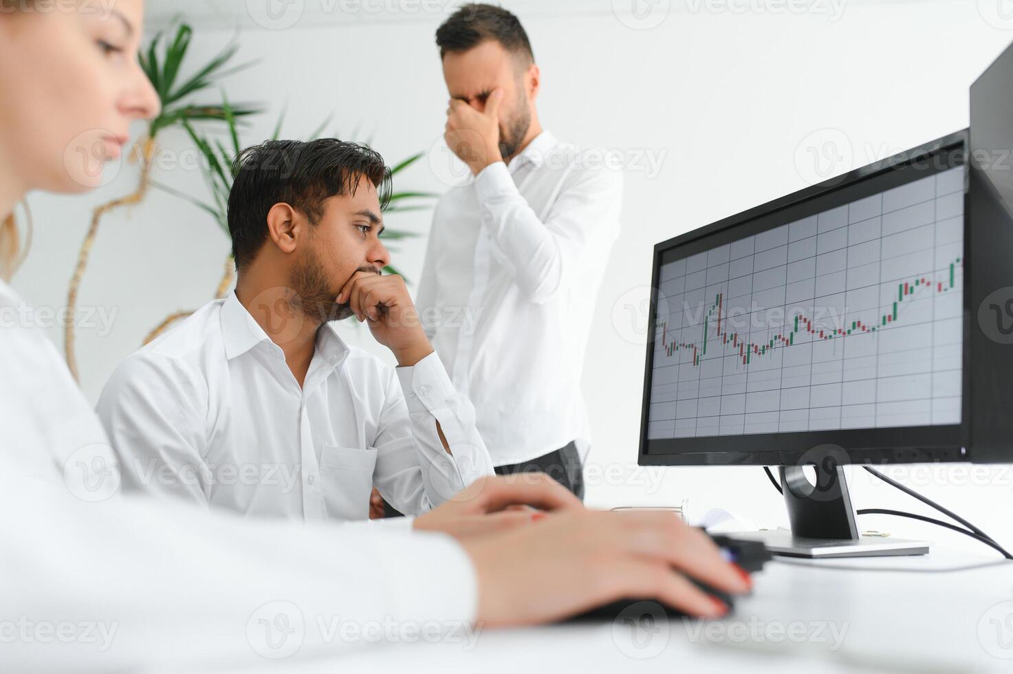 Business professionals. Group of young confident business people analyzing data using computer while spending time in the office photo