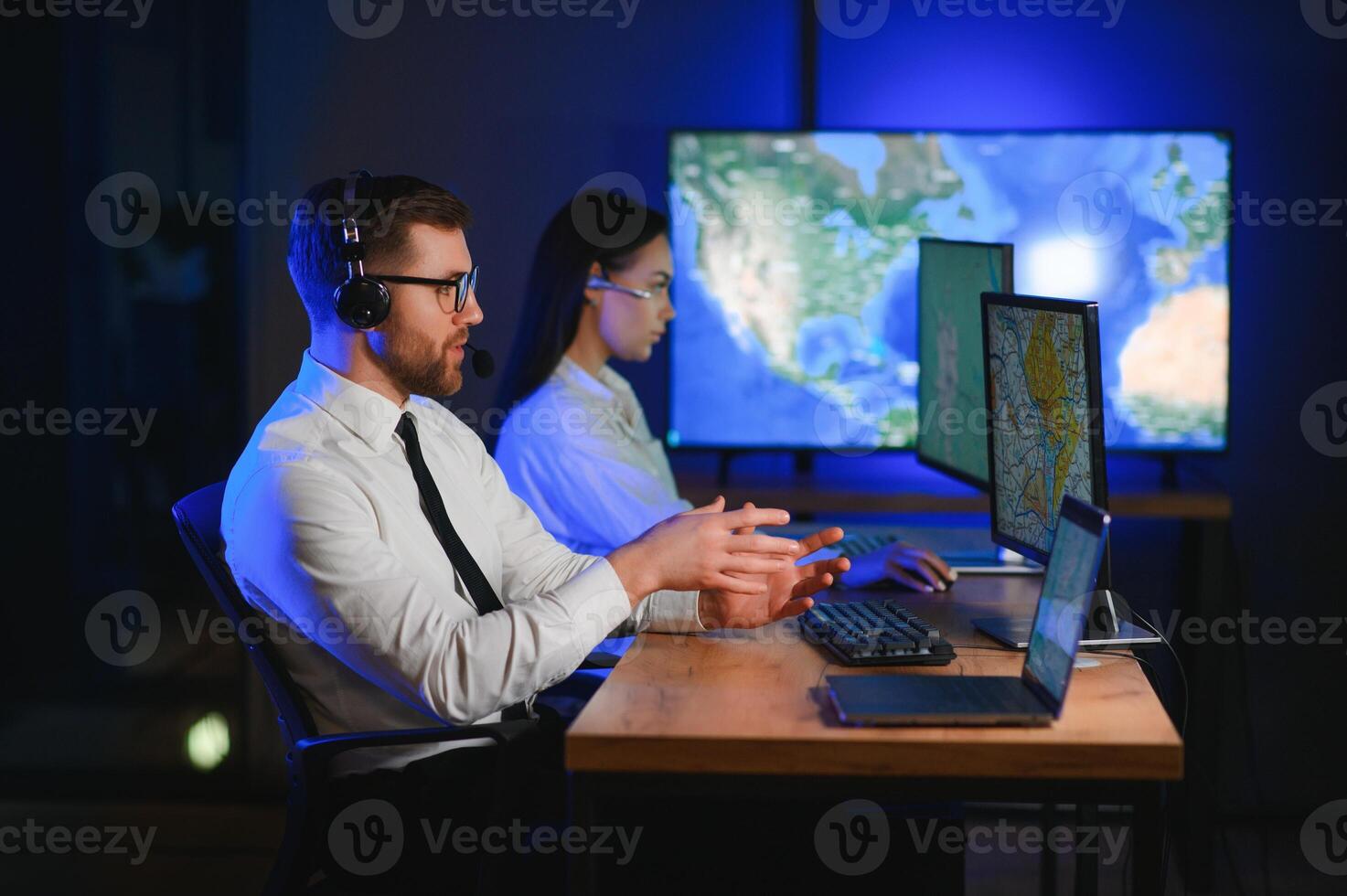 Center of dispatching maintenance. Portrait of cheerful woman and man working via headset microphone while sitting on navigation controller board photo