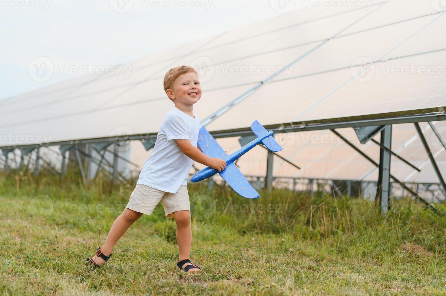 A little boy is having fun near the solar panels. The concept of solar energy. photo