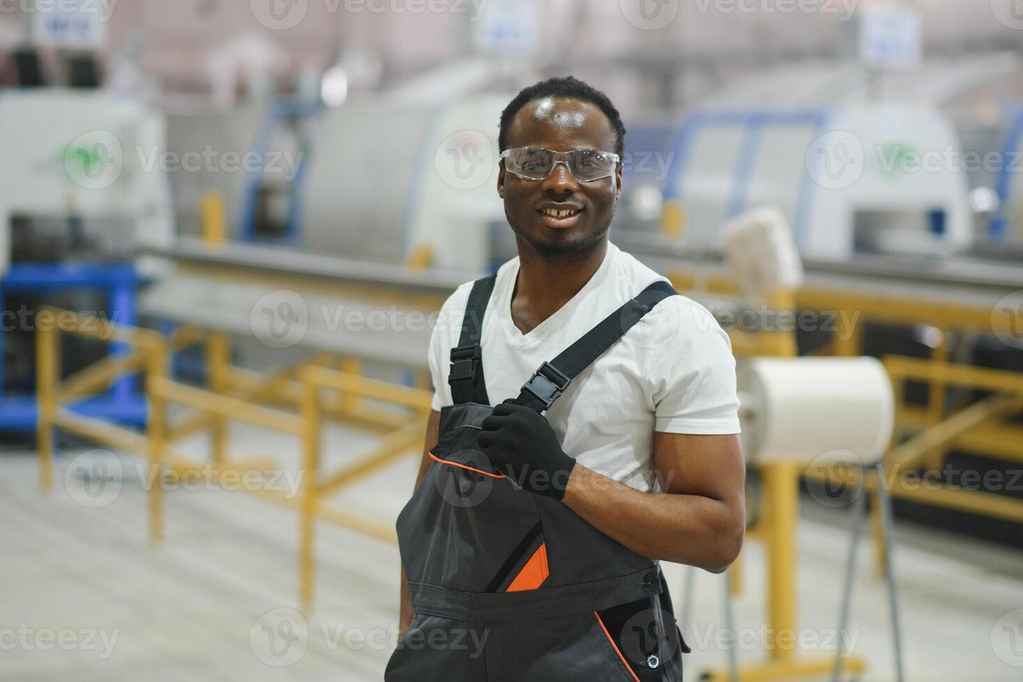 trabajador industrial en el interior de la fábrica. joven técnico con casco naranja foto