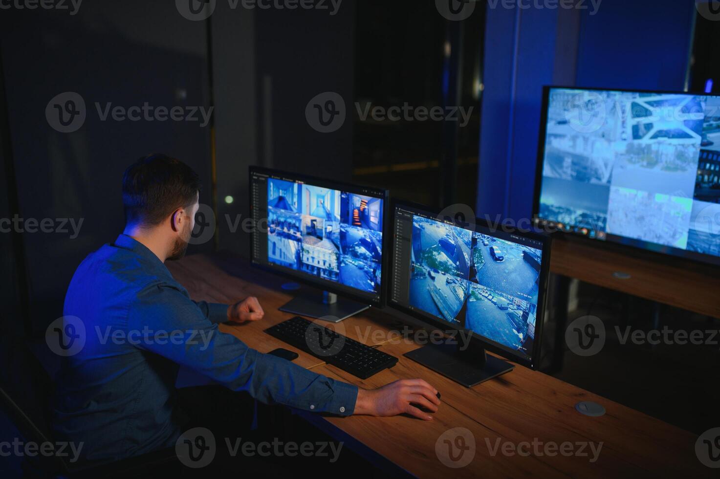 Security operator controls CCTV cameras in office at night. Modern security system and social safety concept photo