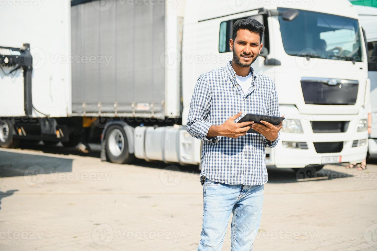 Young indian man standing by his truck. The concept of freight transportation. photo