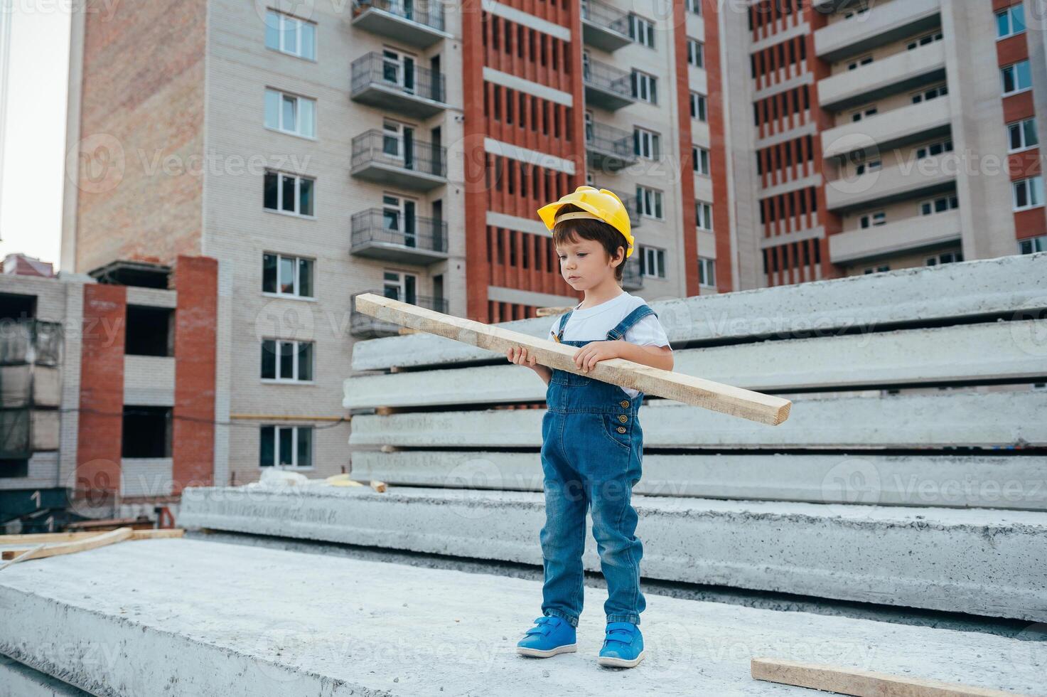 Architect in helmet writing something near new building. little cute boy on the building as an architect. photo