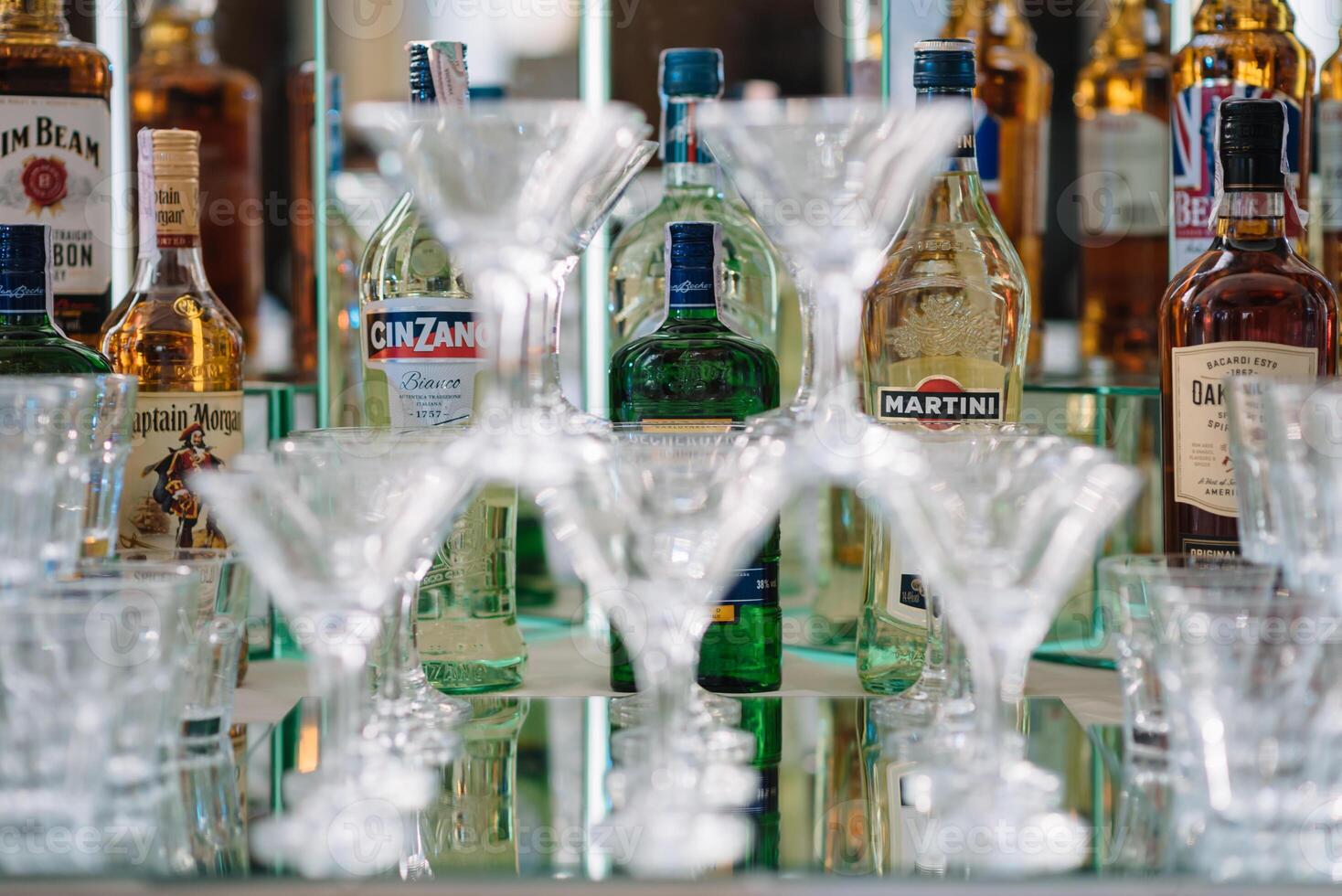 Beautiful line of different coloured cocktails on a party, tequila, martini, vodka, and others on decorated catering bouquet table on open air party, tropic beach hawaiian party setting. photo