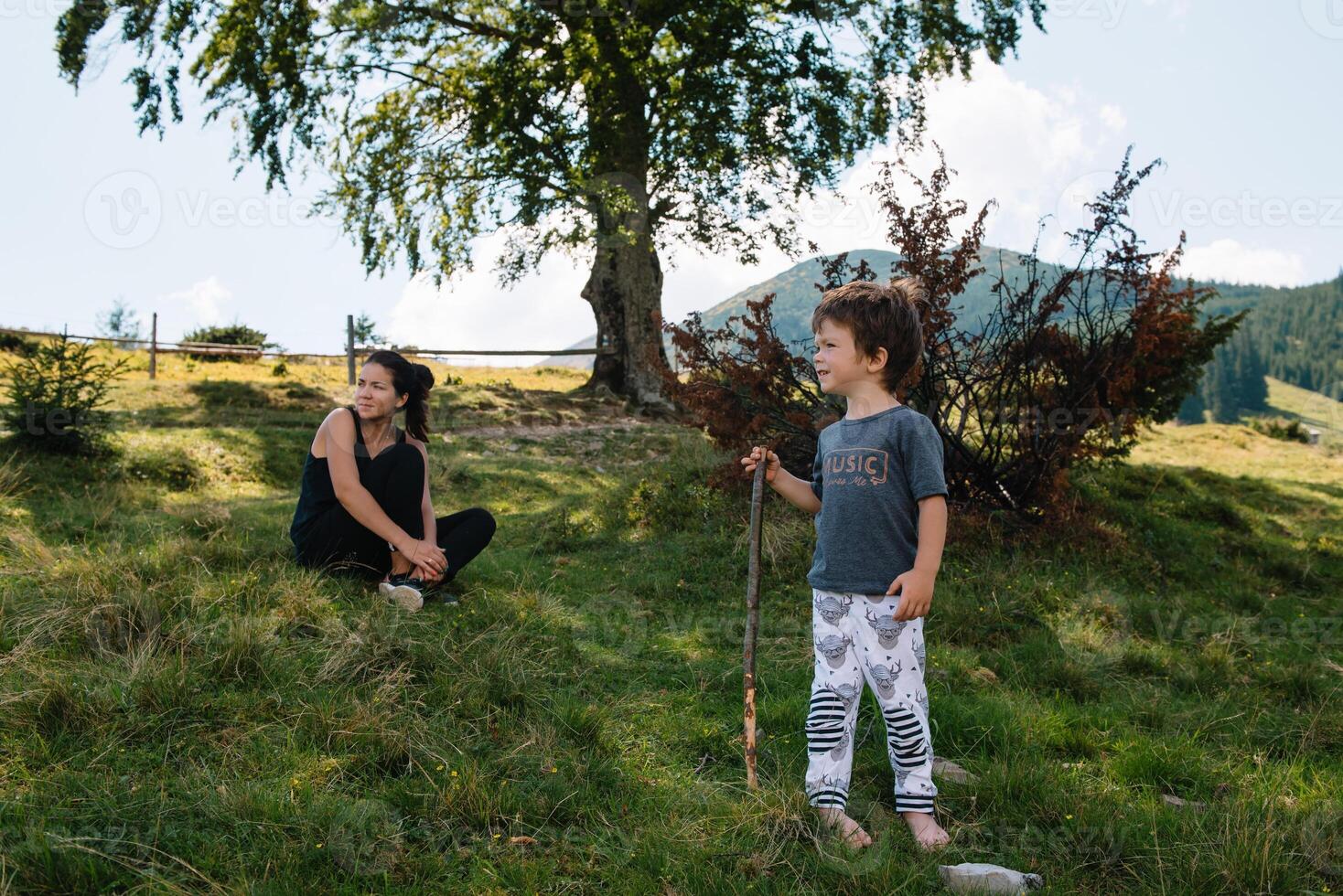 joven mamá con bebé chico de viaje. madre en excursionismo aventuras con niño, familia viaje en montañas. nacional parque. caminata con niños. activo verano vacaciones. ojo de pez lente. foto