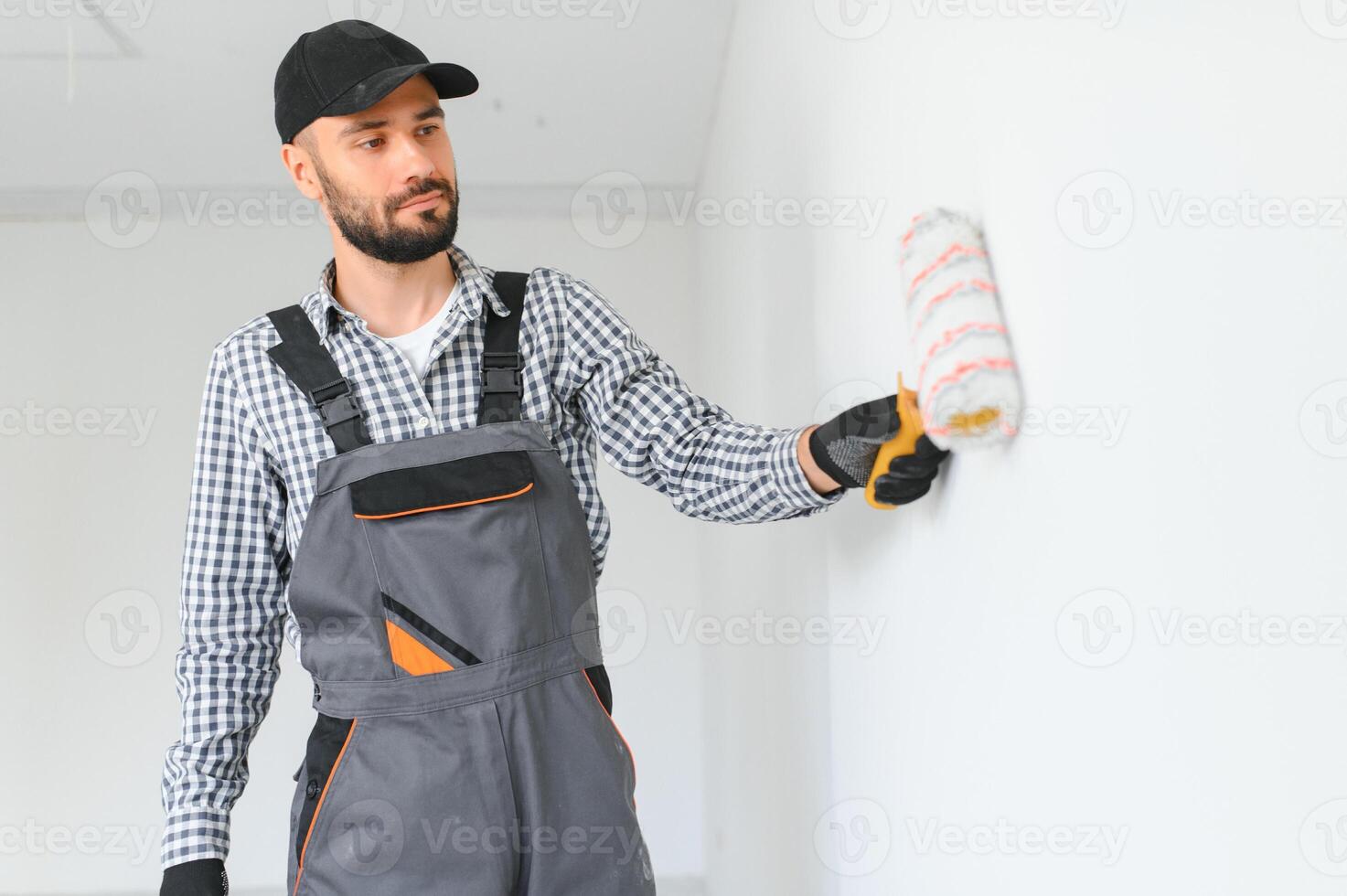 Young worker painting wall in room. photo