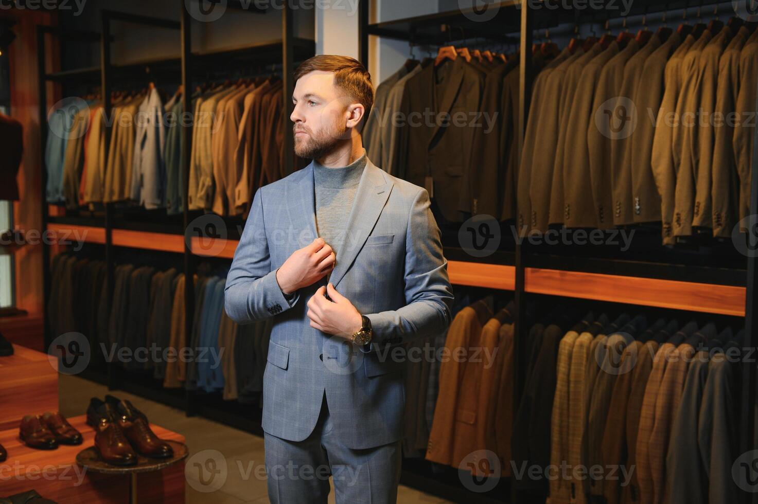 venta, compras, moda, estilo y personas concepto - elegante joven hombre en traje en centro comercial o ropa Tienda foto