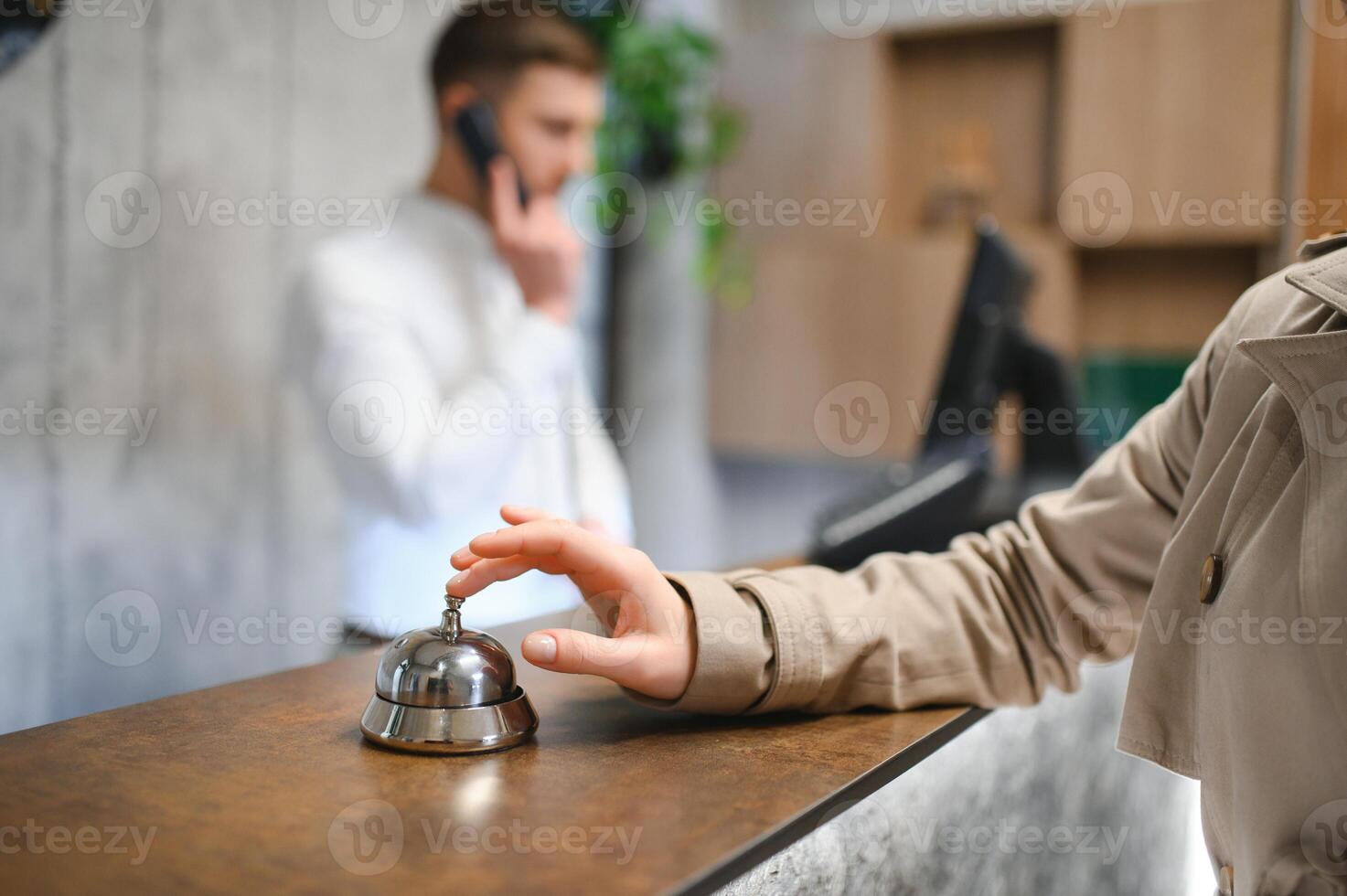 Hand of a woman using a hotel bell photo
