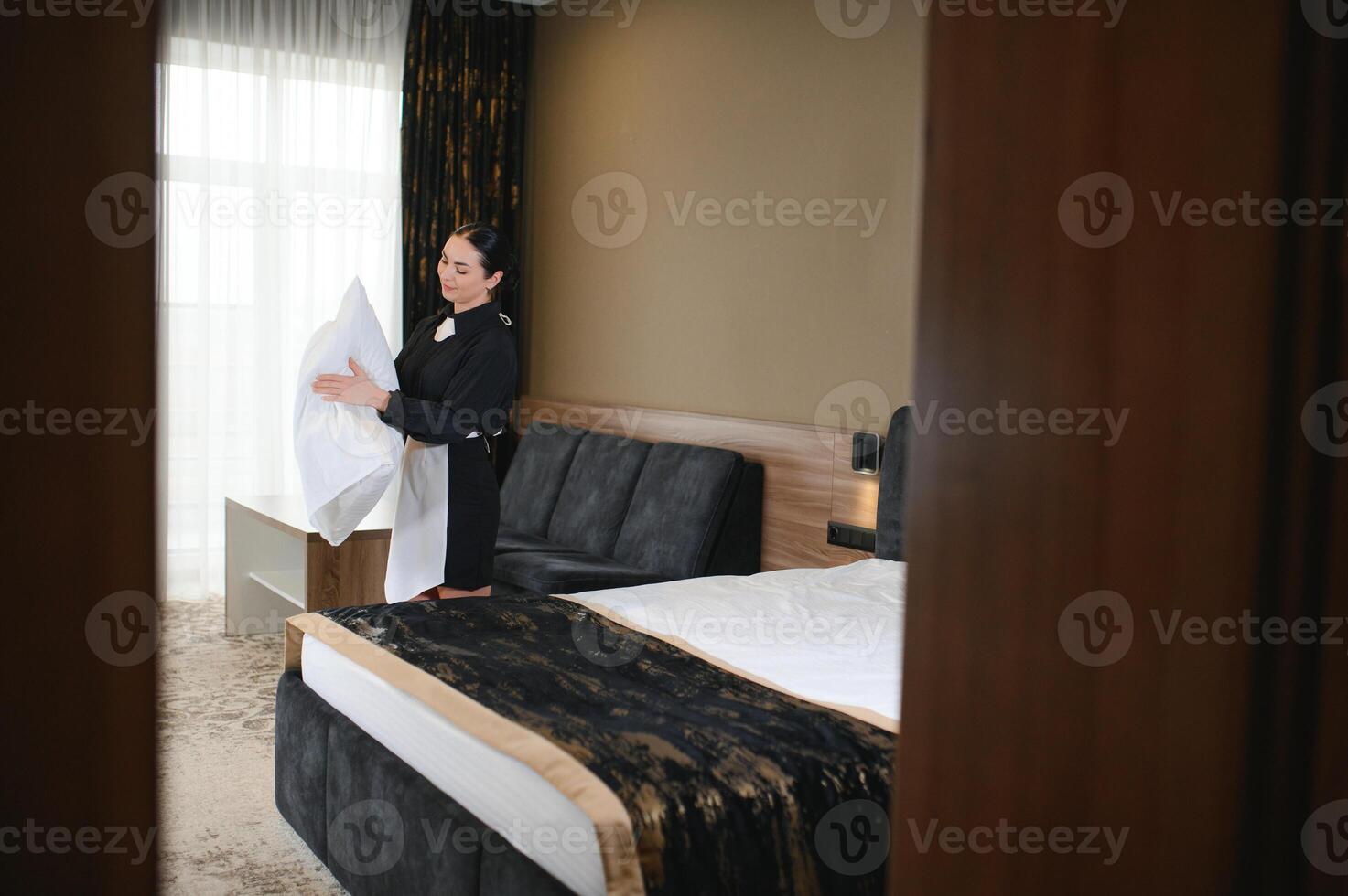 Young hotel maid making the bed photo