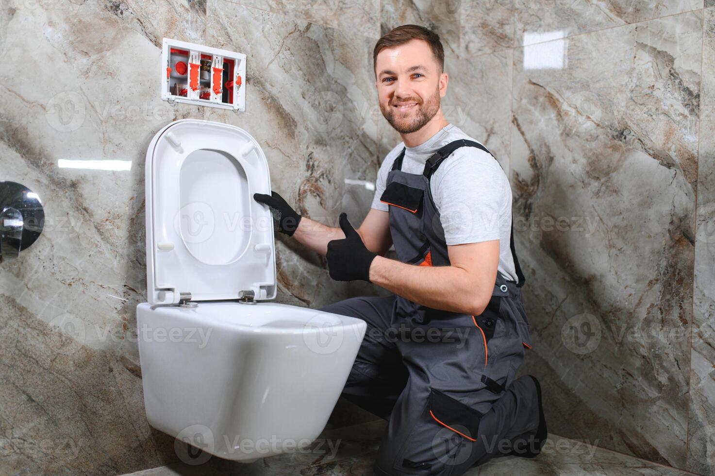 Plumber installing toilet in restroom photo