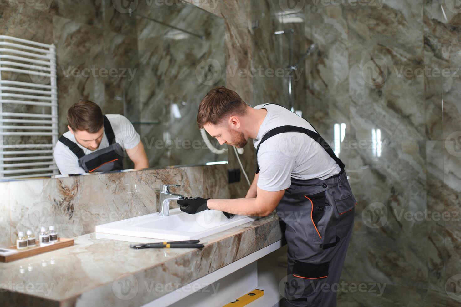 fontanero reparando el grifo de un lavabo foto