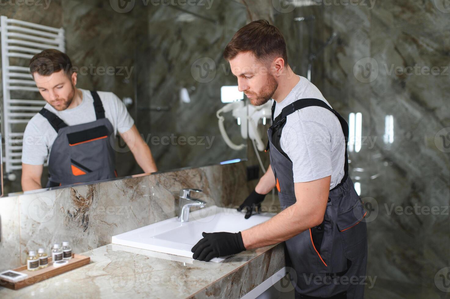 Handsome plumber working in restroom photo