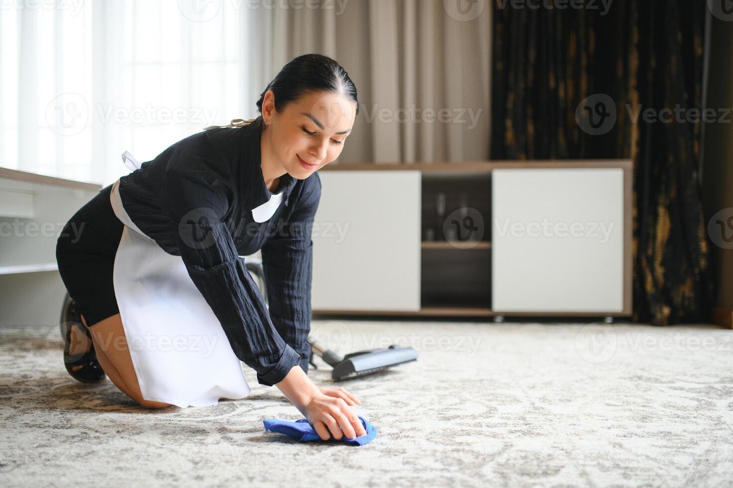 Professional chambermaids cleaning floor in hotel room photo