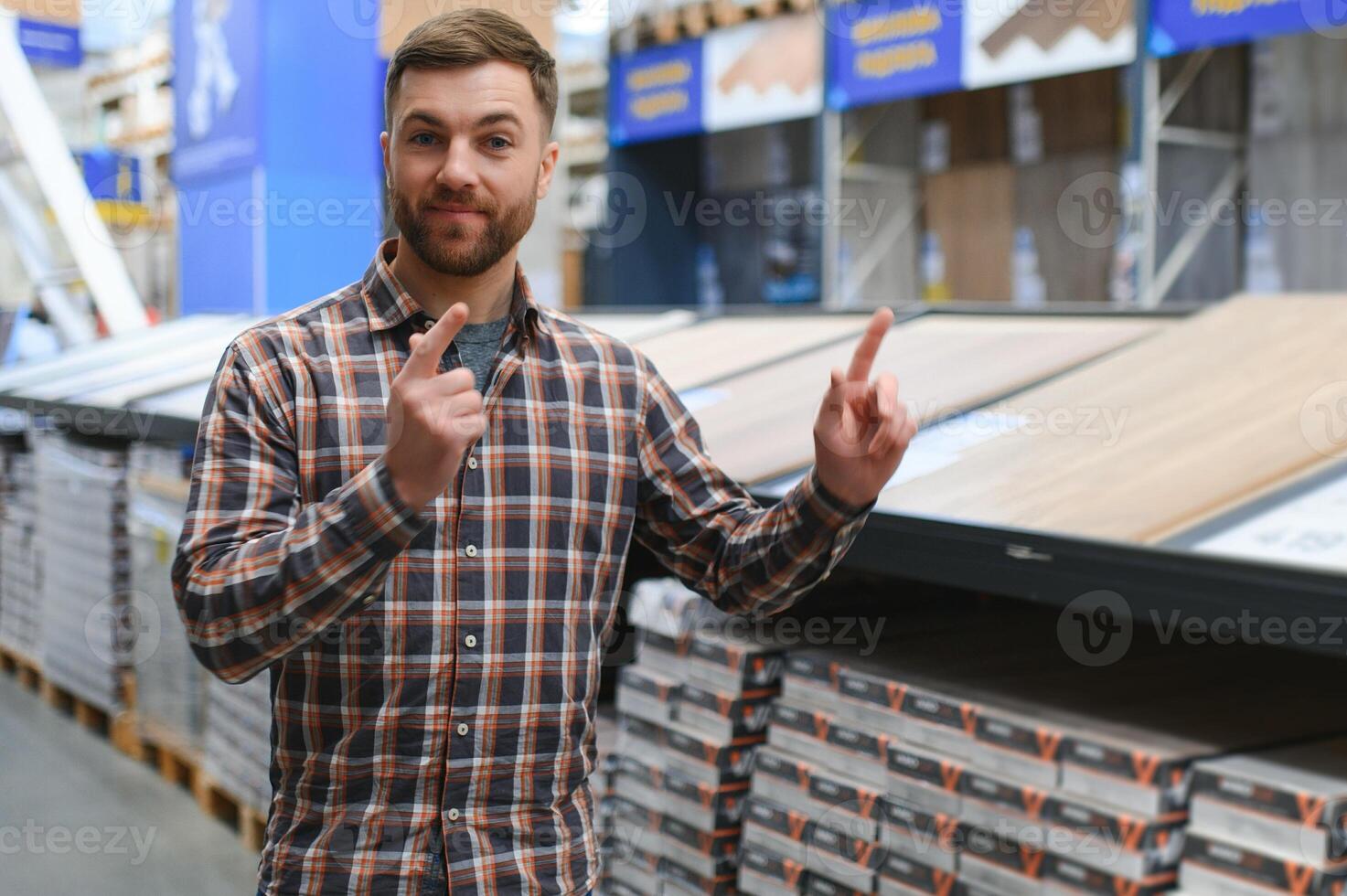 A male salesman-consultant in a hardware store sells laminate photo