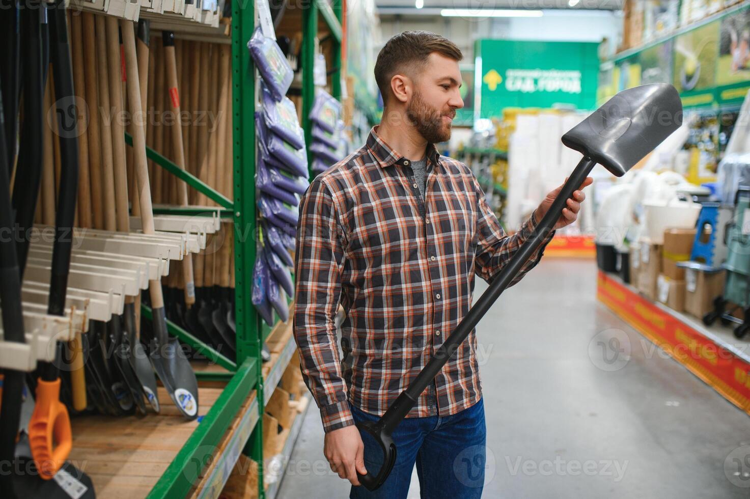 retrato de un contento hombre participación pala en hardware Tienda foto