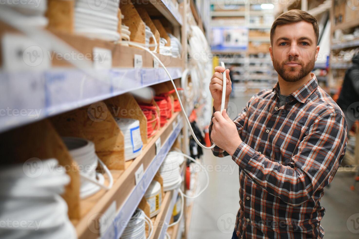 Worker selects an electrical cable at a hardware store photo