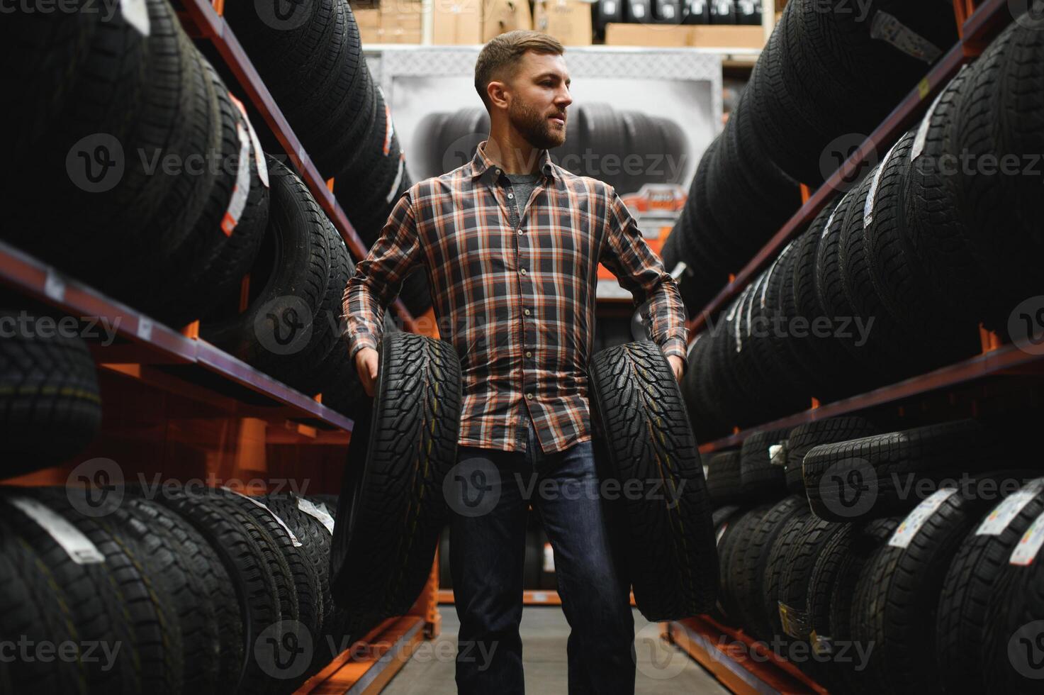 Male mechanic with car tires in automobile service center photo