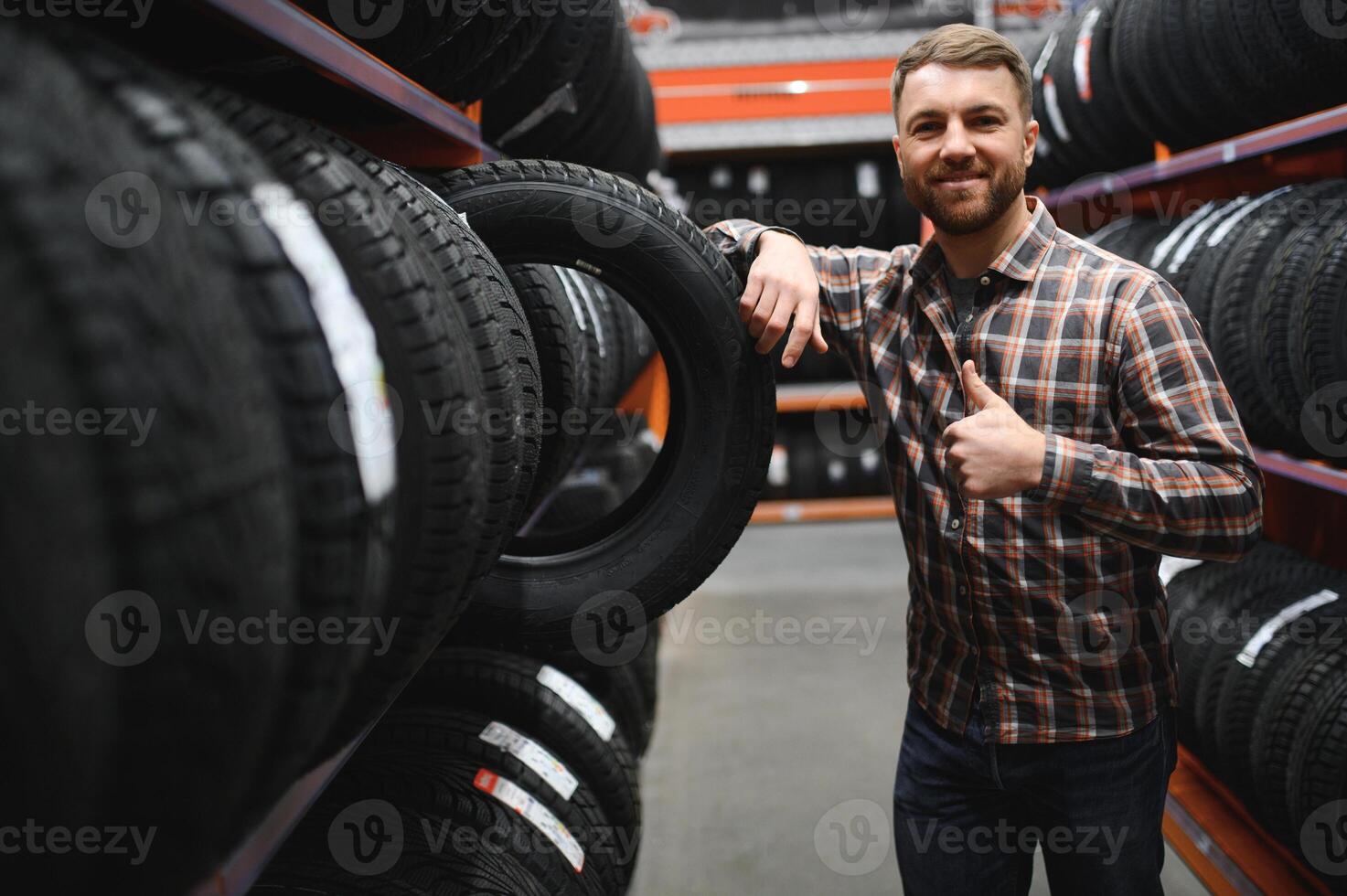 hombre elige invierno coche llantas en el auto tienda foto