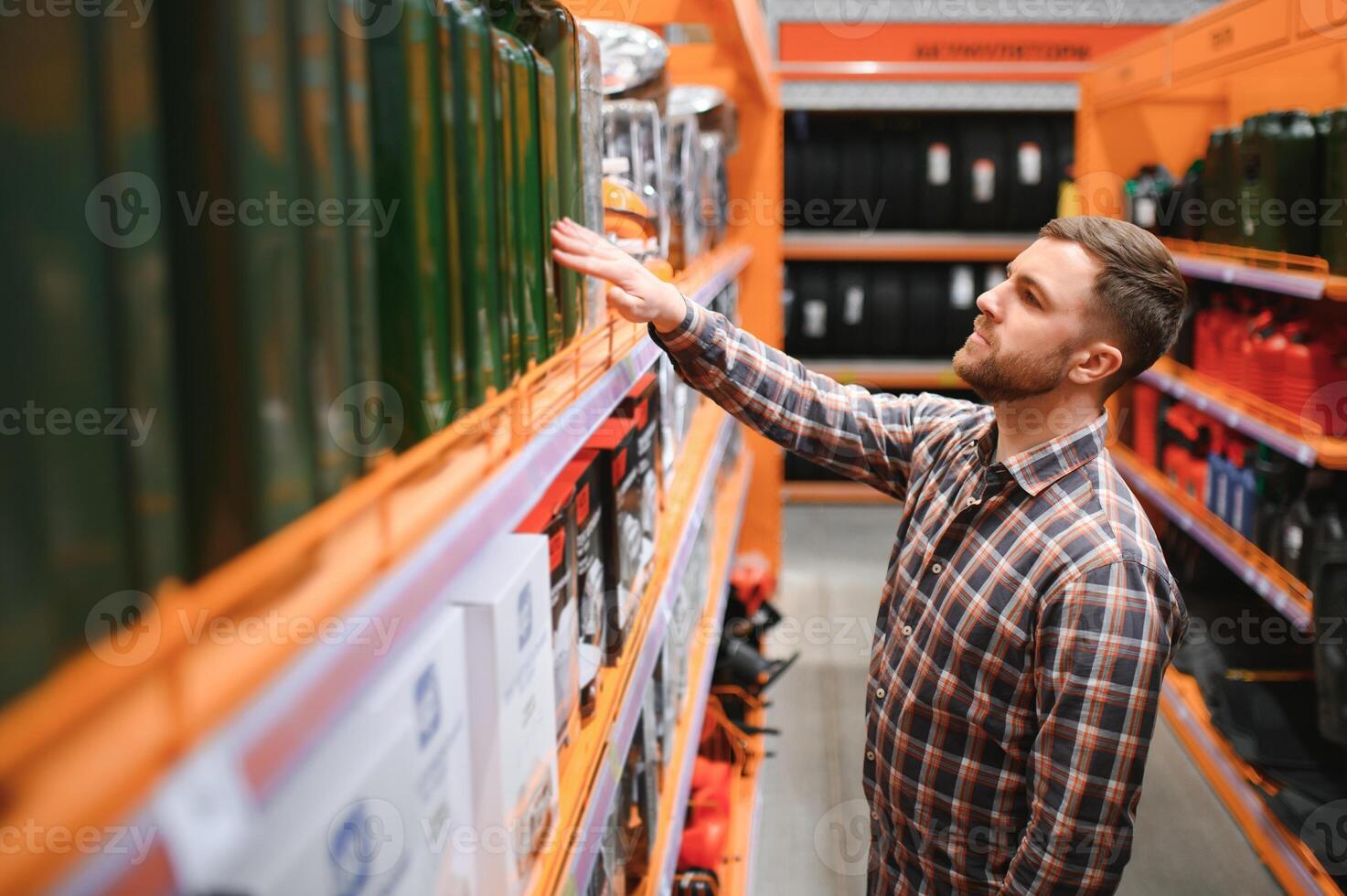 un masculino cliente soportes en un auto partes Tienda con un alemán lata foto