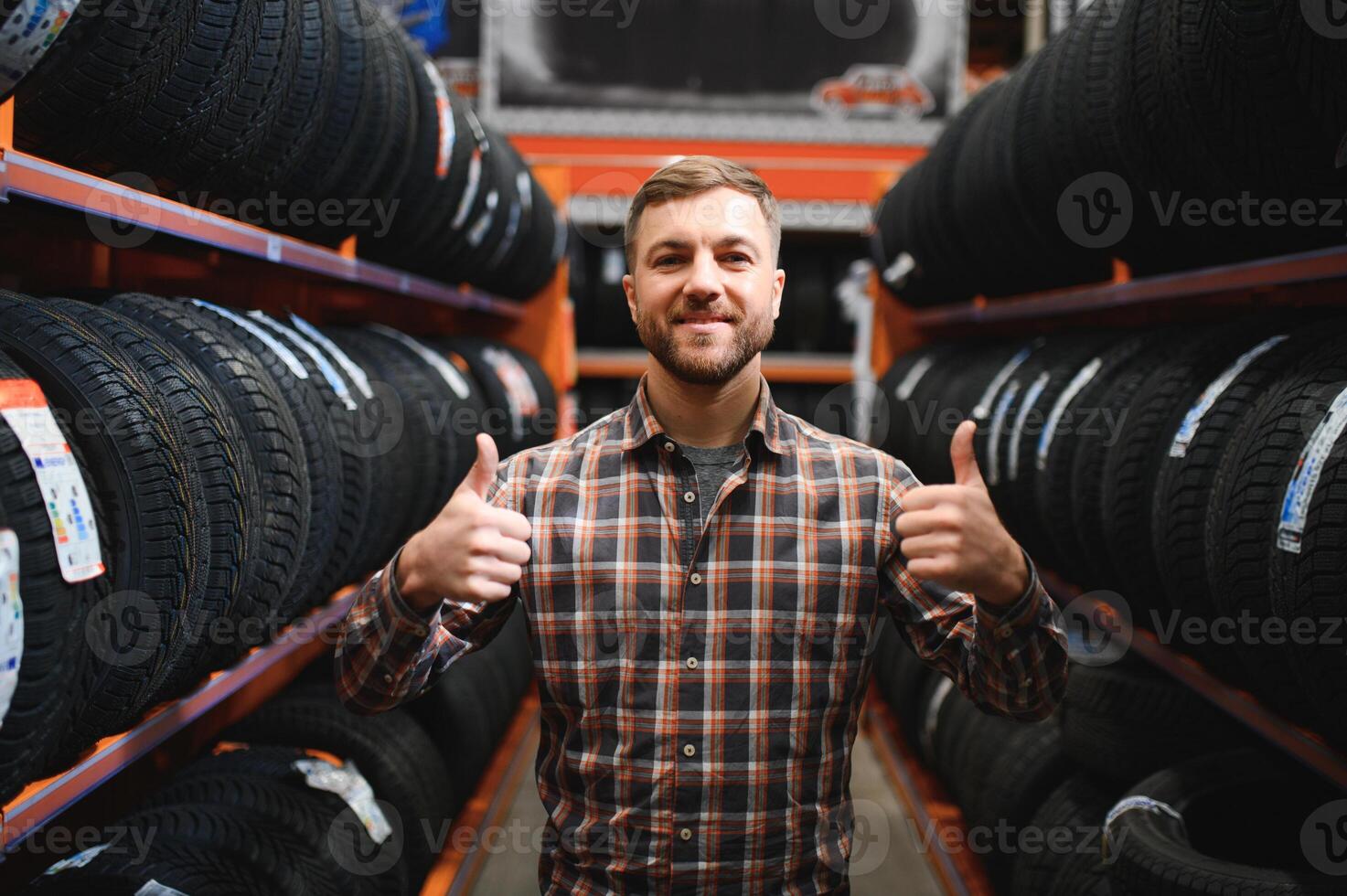 Male mechanic with car tires in automobile service center photo